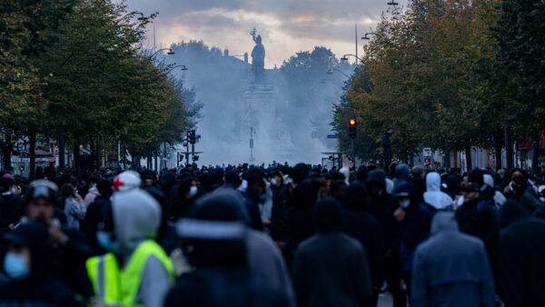 File photo: a large crowd at Place de la République in Paris during protests on 17 October 2026, with tear gas in the air.