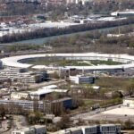 Aerial view of the European Synchrotron Radiation Facility in Grenoble, France, showing its ring-shaped synchrotron building.