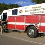 File photo: a firefighter in a hazmat suit climbing into a regional hazardous materials response unit in the US Midwest.