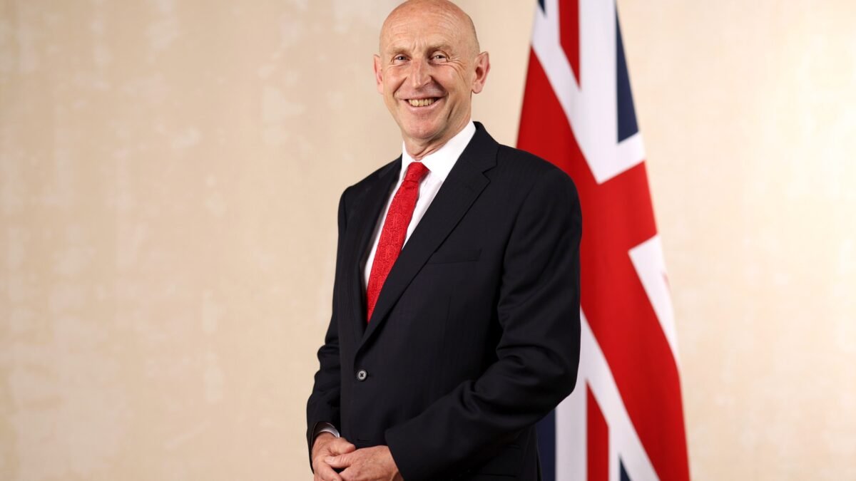 Official cabinet portrait of Chancellor John Healey beside a Union flag.