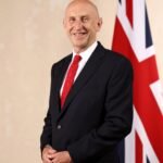 Official cabinet portrait of Chancellor John Healey beside a Union flag.