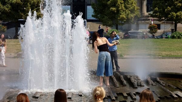 File photo: people cool off at the Lustgarten fountain in Berlin, Germany, during the June 2026 heatwave.