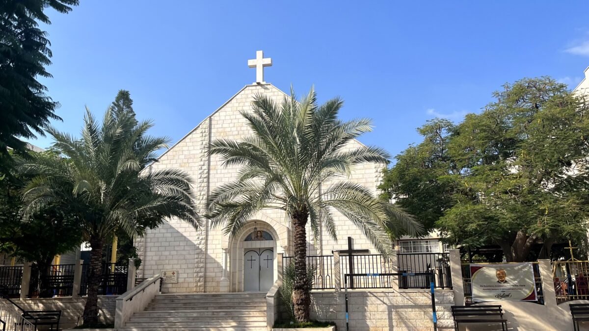 Holy Family Church in Gaza City photographed on 29 November 2022, its stone facade and cross framed by palm trees under a clear blue sky. File photo.