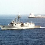 File photo: an oil tanker transits the Strait of Hormuz as the frigate USS Taylor passes.