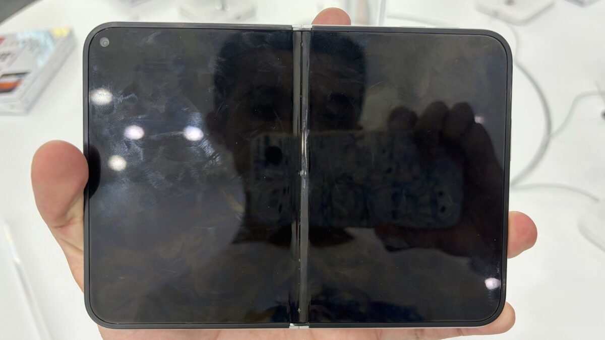 An open iPhone Duo foldable phone held in a hand, showing the unfolded tablet-sized inner display with its center hinge.