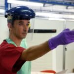 File photo: a health worker in protective gear demonstrates temperature screening with an infrared thermometer during an Ebola-response training exercise.
