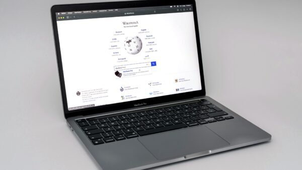 A silver MacBook Pro laptop open on a plain background, showing its keyboard and screen.