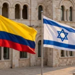 Colombian and Israeli flags flying side by side in front of a Jerusalem stone building, marking the opening of Colombia's embassy in Jerusalem.