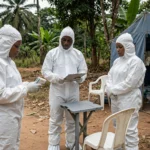 Health workers in full protective suits at an Ebola screening checkpoint in rural Democratic Republic of Congo