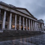 Historic stone Crown Court building with tall columns in London under an overcast evening sky