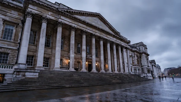 Historic stone Crown Court building with tall columns in London under an overcast evening sky