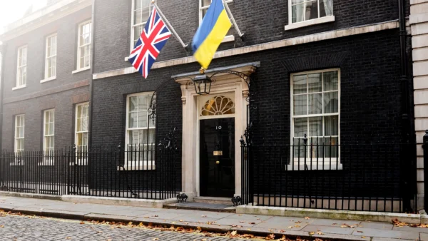 10 Downing Street in London with the British Union Jack and Ukrainian flags flying side by side above the black front door on an autumn morning