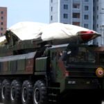 A North Korean ballistic missile on a large transporter vehicle during a military parade in Pyongyang, partly covered by a white sheet.