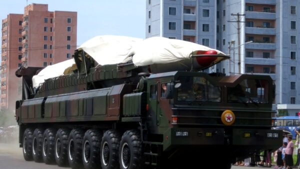 A North Korean ballistic missile on a large transporter vehicle during a military parade in Pyongyang, partly covered by a white sheet.