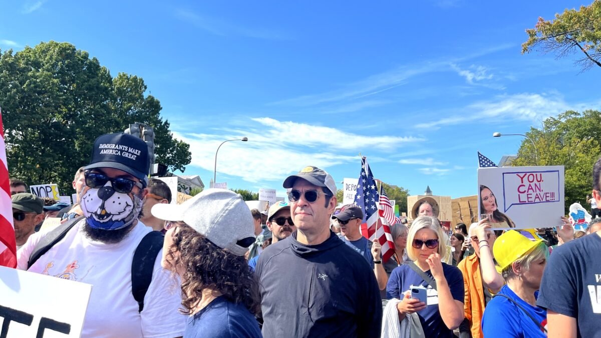 Protesters carrying US flags and signs at a No Kings rally in Washington, D.C. — file photo from the October 2025 demonstration.