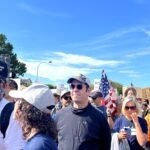 Protesters carrying US flags and signs at a No Kings rally in Washington, D.C. — file photo from the October 2025 demonstration.