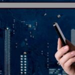 File photo: A hand holding a smartphone against a digital circuit-board background.