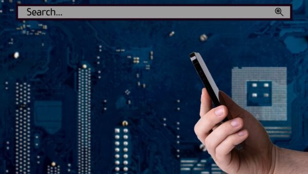 File photo: A hand holding a smartphone against a digital circuit-board background.