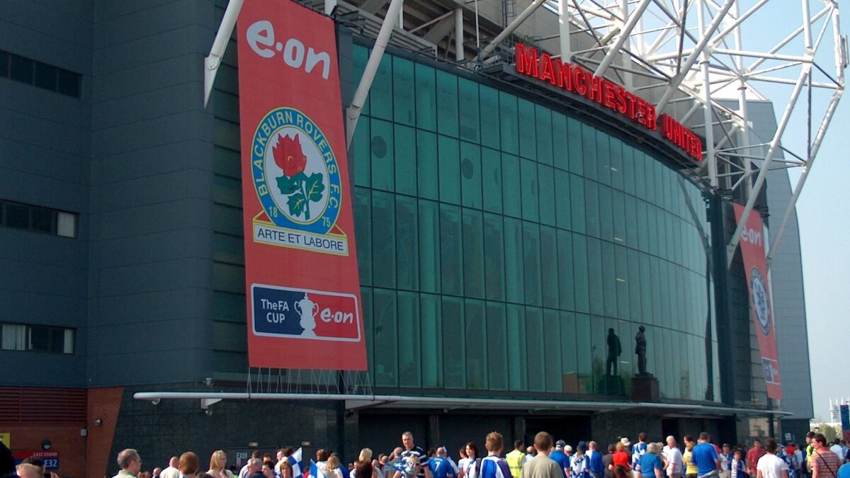 File photo: the Sir Matt Busby Way end of Old Trafford, Manchester, with the Manchester United sign above the glass frontage.