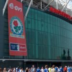 File photo: the Sir Matt Busby Way end of Old Trafford, Manchester, with the Manchester United sign above the glass frontage.