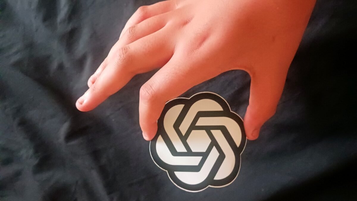 File photo: the OpenAI logo on a sticker held in a hand.