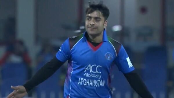 Rashid Khan celebrating a wicket for Afghanistan in his blue team jersey.