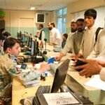 File photo: Afghan customs officials check travellers' passports at the Torkham border crossing in Nangarhar province, Afghanistan, in April 2013.