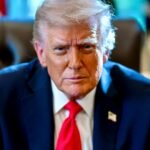 US President Donald Trump seated at the Resolute Desk in the Oval Office — official June 2026 White House portrait.