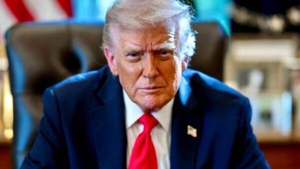 US President Donald Trump seated at the Resolute Desk in the Oval Office — official June 2026 White House portrait.